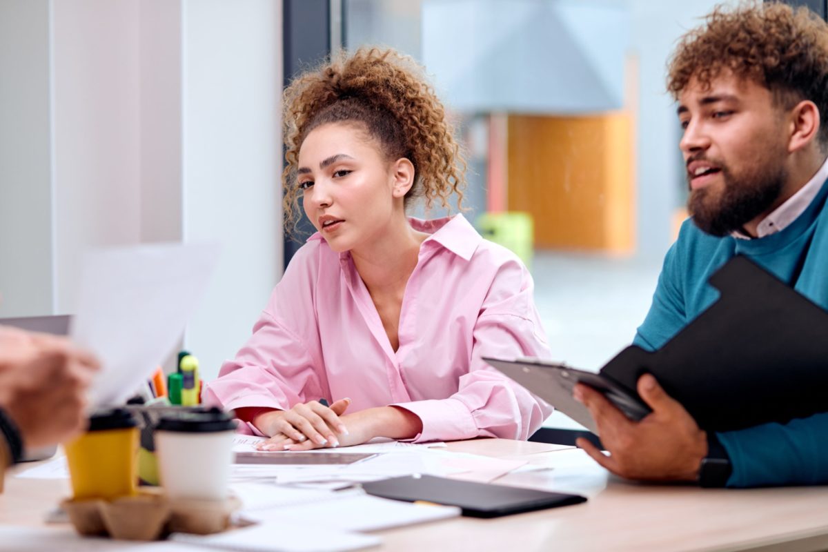 Young Adult Female Looking Pensive in a Professional Setting Near Male Coworker