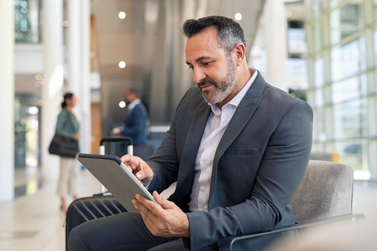 Working man, sitting, reading on an iPad