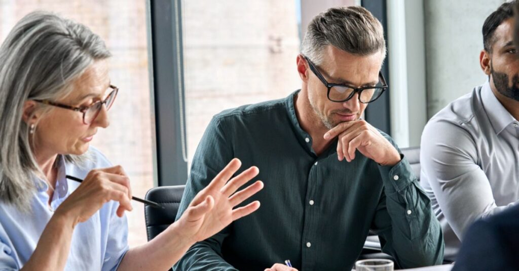 Two men listening while a woman talks