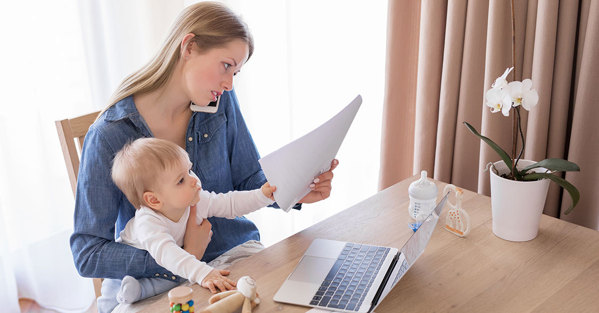 Woman holding a baby while talking on the phone and reading a document