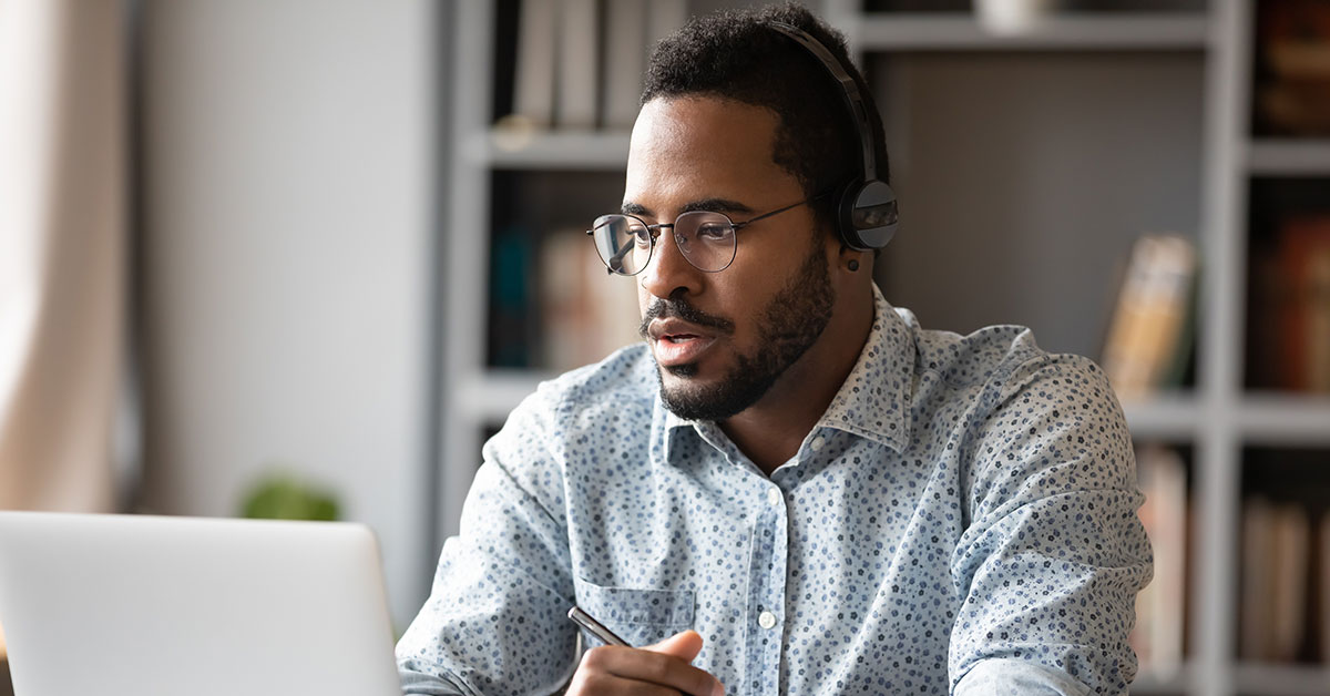 Man wearing a headset looking at a computer